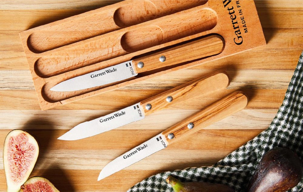 Set of Garrett Wade knives - 3 total. With knife holder. Cut fruit next to them on a wood table.