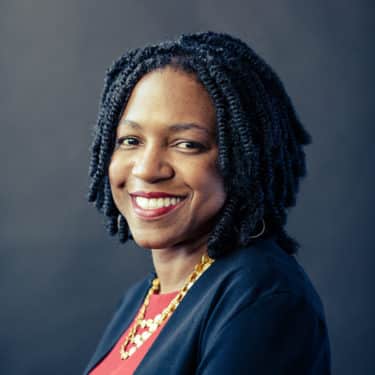 Stacy Brown-Philpot headshot _ Black woman smiling in front of grey wall